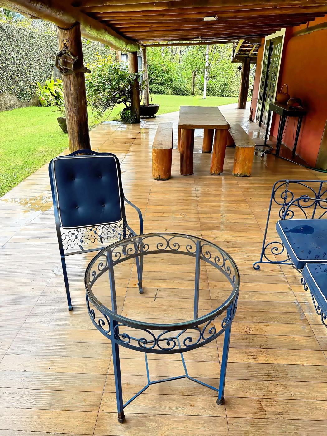 Varanda com mesa rústica e móveis de ferro